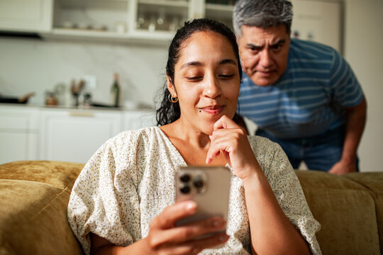 Middle aged couple using smartphone at home