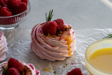Pink raspberry meringues filled with lemon curd and fresh raspberries , decorated with crushed...