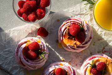 Pink raspberry meringues filled with lemon curd and fresh raspberries , decorated with crushed...