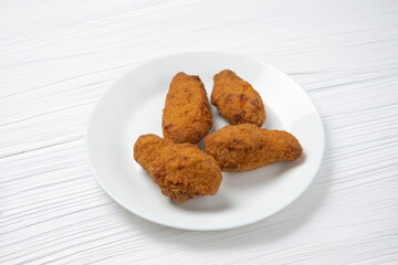 Fried chicken nuggets on white plate on white background