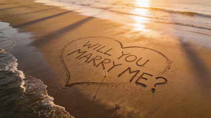 Aerial sunrise beach proposal with “Will You Marry Me” written in wet sand inside a heart, ocean waves nearby, long morning shadows, epic scale, natural romantic scene, no people.