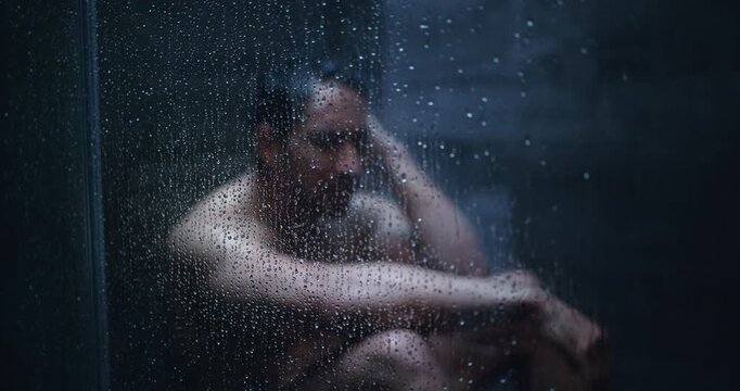 Shower, thinking and man with depression in home, mental health and remember memory for despair. Glass, grief and frustrated person overwhelmed by loss, negative perspective or reflection in bathroom