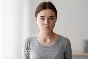 Sad unhappy european millennial woman suffering from depression and looking at camera at home...