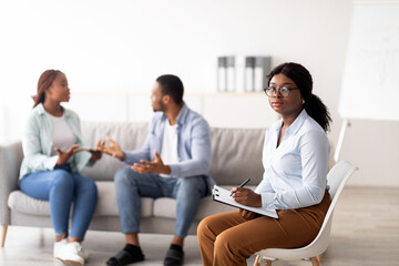 Female psychologist and young black couple having conflict during marital therapy at office, copy space. Psychotherapist having session with African American family. Marriage problems concept