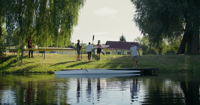 Athletes with oars in their hands prepare for the race.