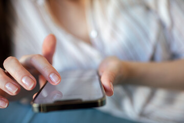 Close-up of hands using smartphone at home