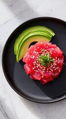 Freshly prepared sashimi-style tuna arranged beautifully on a black plate with avocado slices and sesame seeds, showcasing vibrant colors and culinary artistry