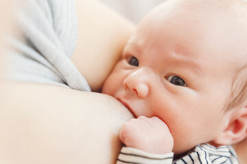 Mother breastfeeding baby. Baby eating mother's milk.