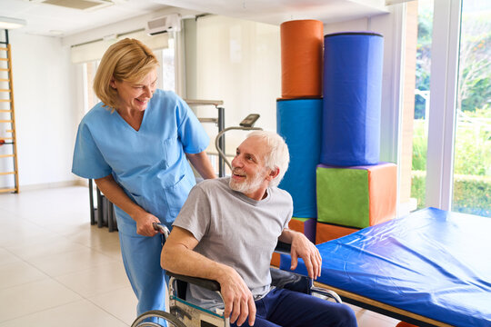 Senior Man in Wheelchair with Physiotherapist Assisting in Rehab Center Indoor Recovery and Rehabilitation After Injury or Surgery