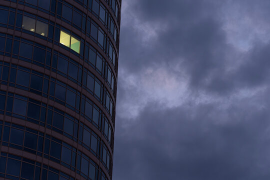 Modern architecture skyscraper in Frankfurt Germany, curved glass tower over city with clouds, urban skyline view and copy space for business.