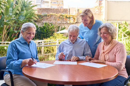 Senior Adults Doing Cognitive Rehabilitation Exercises With Nurse Outdoors At Rehab Center For Brain Injury Recovery And Mental Wellness Support