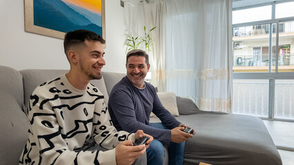 Father and son laughing playing video games bonding