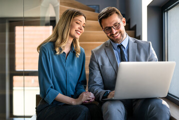 Business team of two executives working together using laptop in office. Technology concept