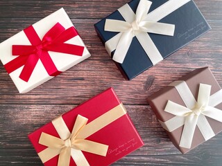 Gift boxes with ribbons on wooden background flat lay
