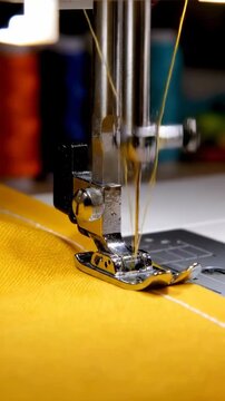 Close-up of sewing machine stitching fabric in studio workspace during afternoon