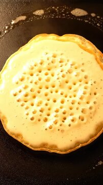 Pancake cooking process on a hot skillet in a kitchen during morning hours