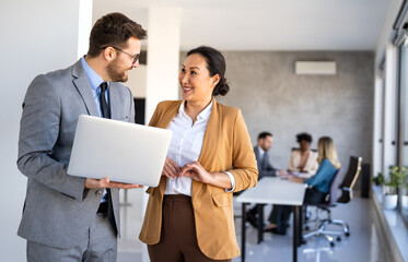 Busy smiling executive business team using digital devices in office. Diverse professional people