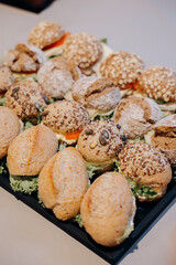 Gourmet sandwich platter with different fillings on a wooden table, catering concept.