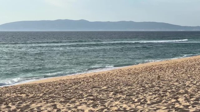 Golden Sand and Ocean Waves with Blue Gray Mountains Revealing Tranquil Luxury Retreat in Comporta Portugal