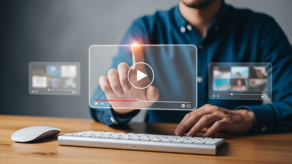 Digital media consumption concept: Professional person tapping a holographic video screen interface floating above a modern keyboard and wooden desk, symbolizing streaming, online content, and technol