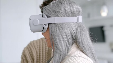 Elderly woman exploring virtual reality with assistance from smiling young man - Powered by Adobe