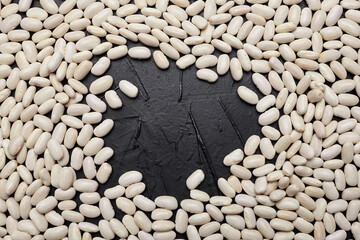 White beans arranged artistically on a dark textured surface, creating a visually appealing pattern that highlights their natural shape and color, perfect for culinary concepts