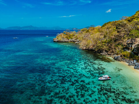 White sand beach with calm turquoise water and lush tropical scenery, capturing the natural beauty of the Philippine coastline