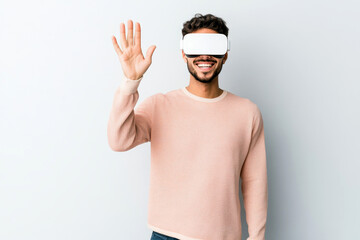 Smiling young man experiencing virtual reality wearing VR headset indoors