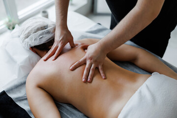Therapist performing deep tissue back massage on woman