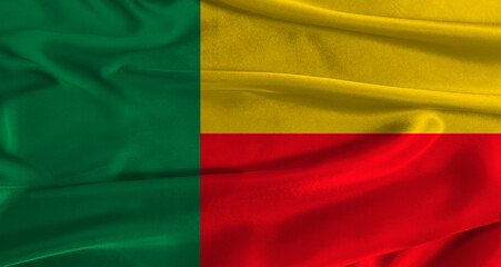 Flag of Benin with fabric textured background. Close up of National flag of Benin with realistic...