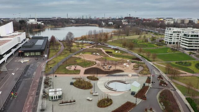 Modern urban recreation zone at Toolonlahti in Helsinki featuring public park areas, walking paths and contemporary buildings by the lake, showing high-quality city leisure environment in Finland.