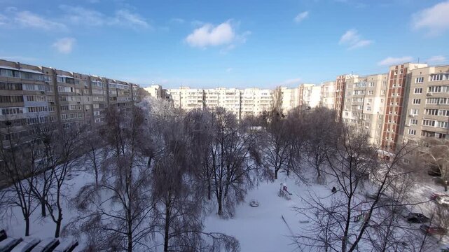 Snowy courtyard between East-europe panel apartment blocks under blue sky, winter. Kyiv, Ukraine.