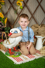 Little Boy Lovingly Embracing White Goose Statue in Charming Countryside Setting