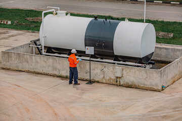 Male worker inspection record drum oil stock barrels white horizontal