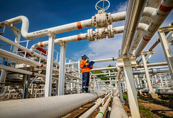 Male worker inspection at steel long pipes and pipe elbow in station oil factory during refinery valve of visual check record pipeline