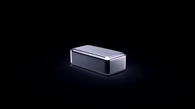 Minimalistic metallic rectangular device slowly rotating on black isolated background with soft studio reflections. Concept of modern technology and product presentation