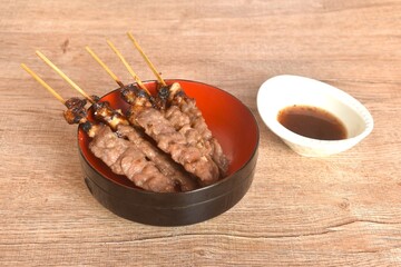 grilled salty beef meat stabbing in wooden stick on bowl dipping spicy tamarind chili sauce