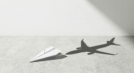 Paper airplane next to shadow of real plane on ground