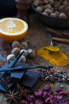 Close-up of a stack of dark Chocolate, nuts, dried fruit and spices on a  wooden table