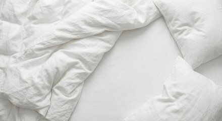 Crisp white bed linens with rumpled sheets and pillows