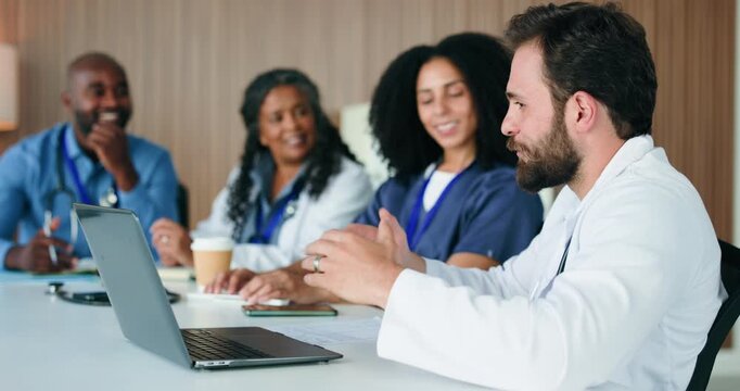 Man, talking and doctors in meeting, laptop or feedback for hospital compliance. People, medical service or review for clinical trial, discussion or email for research funding, internet or healthcare