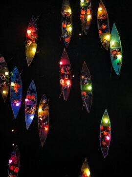 Aerial view of a river alive with vibrant boats glowing with colorful lanterns under the dark night sky, Hoi An, Quang Nam, Vietnam.