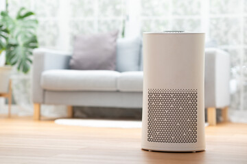 Modern white air purifier machine cleaning dust on wooden floor in comfortable living room creating fresh atmosphere with healthy feeling and peaceful emotion for allergy protection inside home