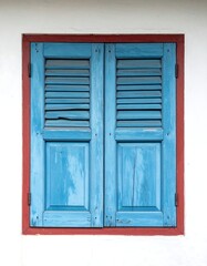 Rustic Blue Window with Red Frame on White Wall.