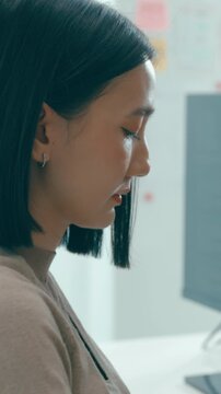 Vertical Screen : Young Asia female freelance typing write prompt AI bot IT app program nomad, video game, terminal with coding language, user interface, designer, big data center on desktop computer.