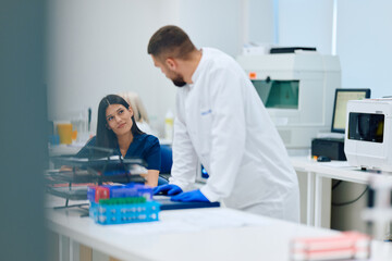 Two professionals engaged in discussion in a modern laboratory setting during working hours