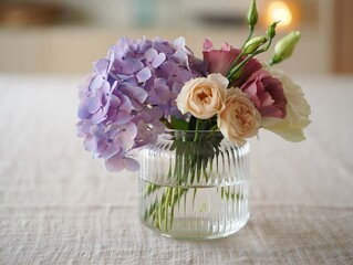 Beautiful bouquet of pink roses arranged in a glass vase with fresh flowers and green leaves