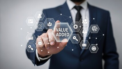 Businessman in suit interacts with virtual interface displaying value added concept with interconnected hexagons and icons