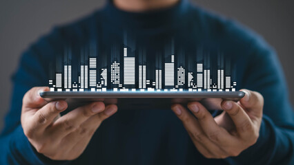 Business technology concept showing a digital city skyline made of data bars floating above a tablet in human hand, representing data analytics, smart city, fintech, innovation, digital transformation