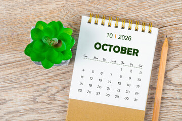 October 2026 monthly desk calendar and pencil with plant pot decoration.
